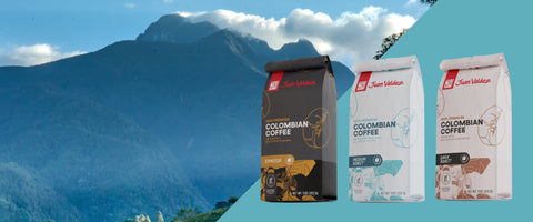 Three packages of Colombian coffee with a mountainous landscape in the background